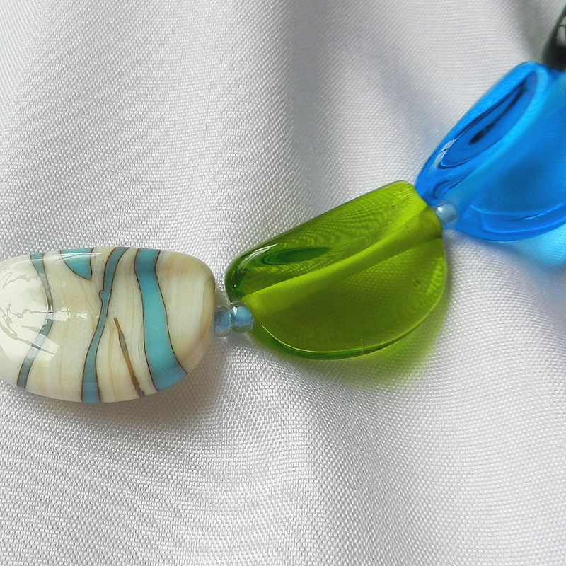 Halskette aus 20 handgefertigten Glasperlen. Unikat von schmuckes Glas. Transparentes grünes und türkisenes Glas. Perlen aus Glas in elfenbein. 52 cm lang.